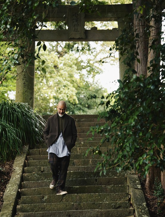 Chef Shinichiro Harakawa descends garden steps wearing IM Men jacket, Stone Island Ghost zip-up jacket, Engineered Garments shirt and trousers, and Visvim trainers.