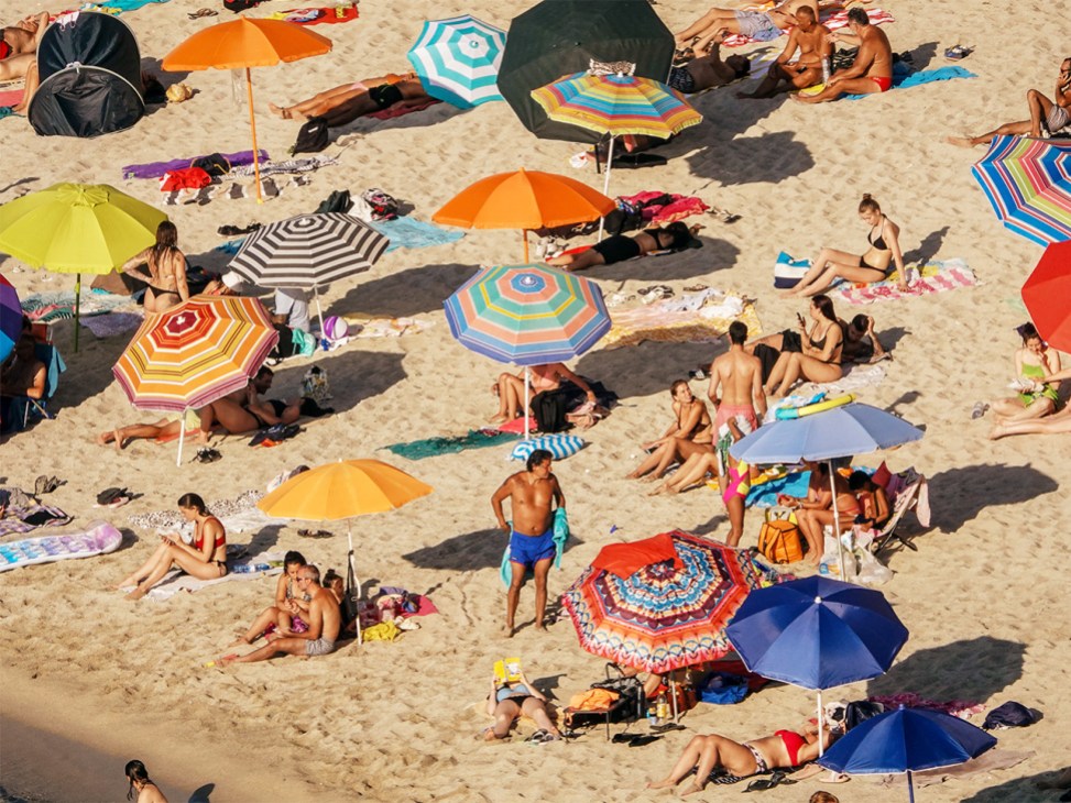 Beachgoers under umbrellas on the sand