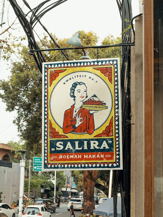 Vintage Salira restaurant signage with retro illustration of woman holding food plate.