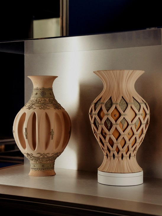 Two wooden vases with carved details displayed on a shelf, showcasing artisanal craftsmanship and design.