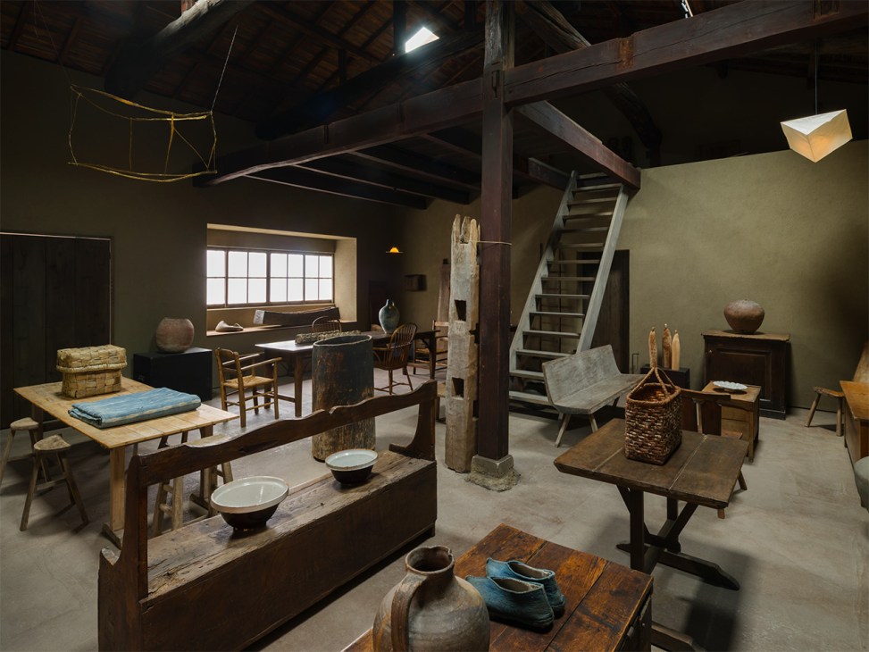 Interior of Kankakari gallery in Kyoto displaying traditional Japanese furnishings, pottery, and wooden furniture in a minimalist exhibition space.