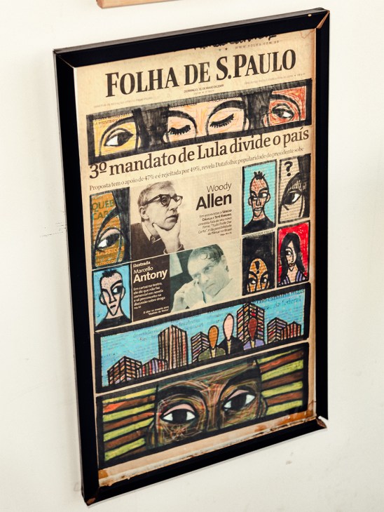 Framed newspaper front page from Folha de S.Paulo featuring illustrated portraits and street art imagery.