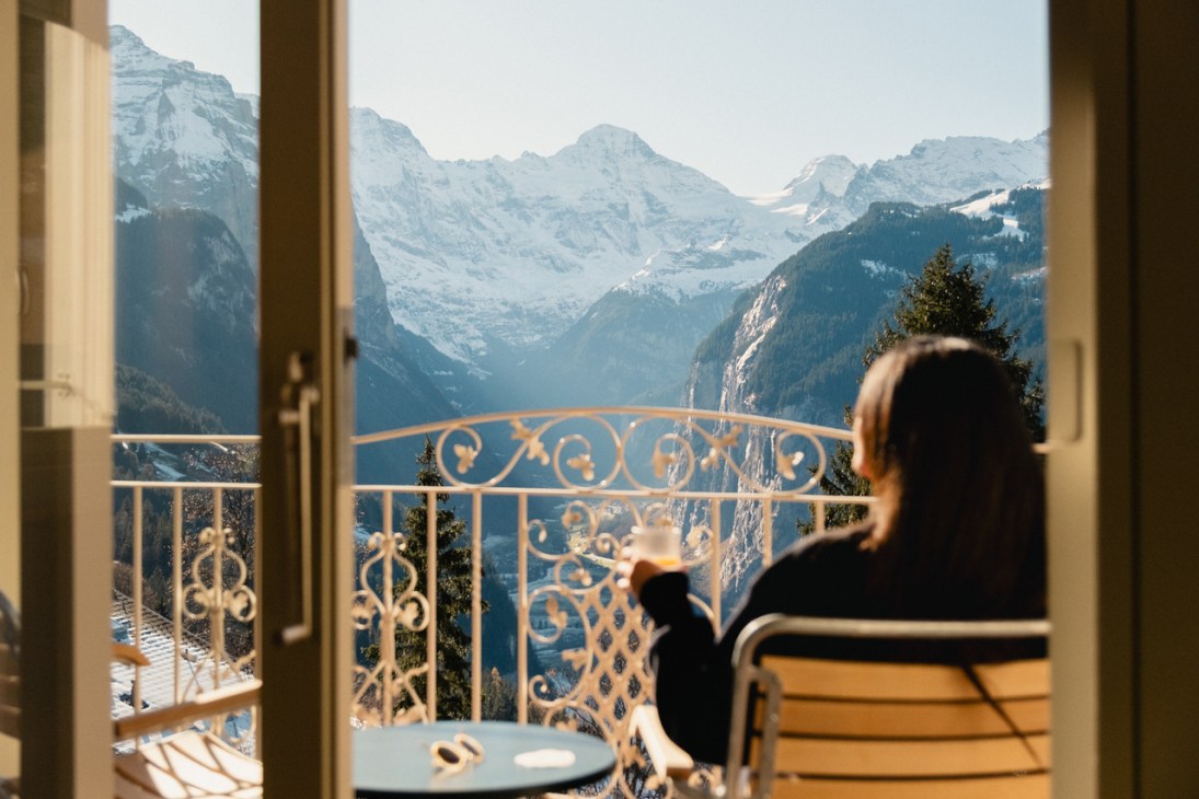 Person relaxing on their balcony overlooking the Alps