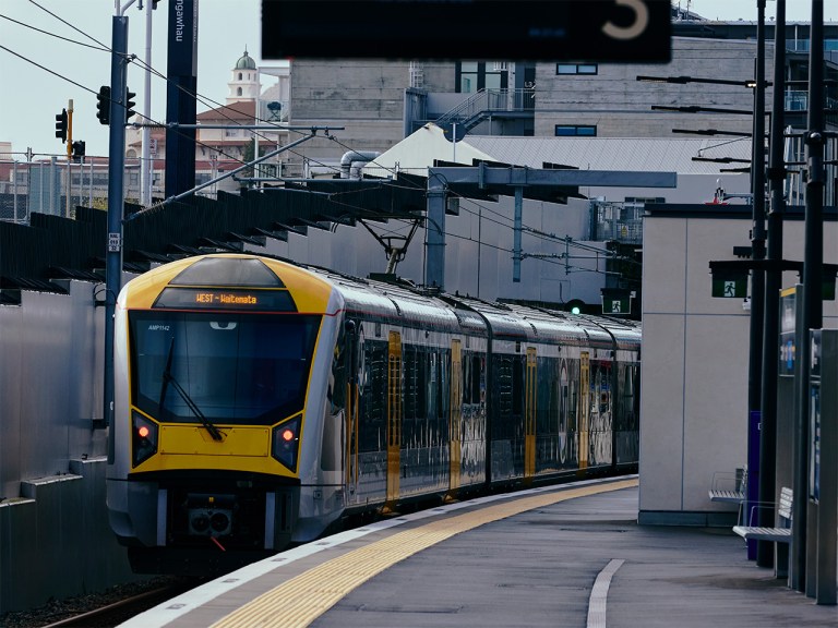 Yellow and silver train pulling into Maungawhau station on the City Rail Link
