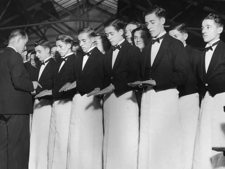 9th November 1936: Young waiters having their hands checked before a day of training at the Ministry of Labour Instructional Centre at Park Royal. Extra waiters are being trained to cope with demand created by visitors in the coronation year. (Photo by Harry Todd/Fox Photos/Getty Images)