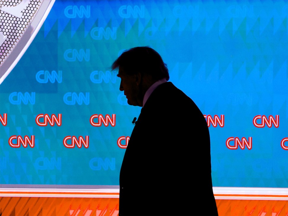 Silhouette of Donald Trump in front of a CNN news screen
