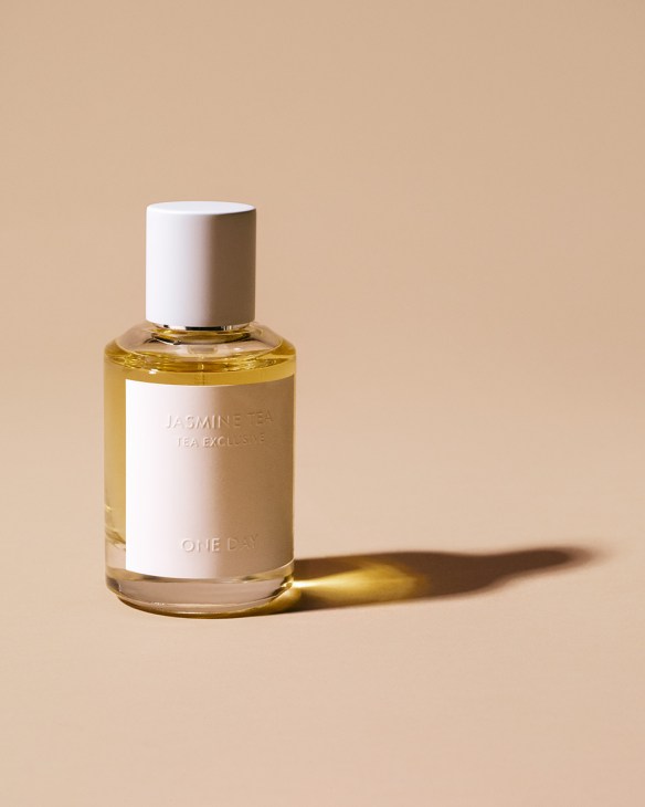One Day Jasmine Tea perfume bottle with white cap and label against beige background