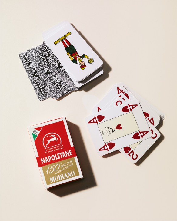 Modiano playing cards displayed on a light background, including Napoletane deck and various other card designs.