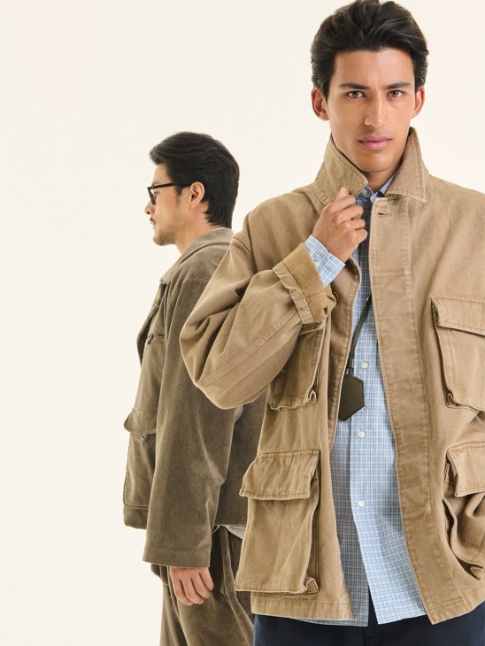 Two men modeling beige cotton-linen jackets: left wears William Frederick jacket with Charlie Chill glasses in profile; right wears Suntosons jacket with blue checkered shirt and Montblanc key holder.