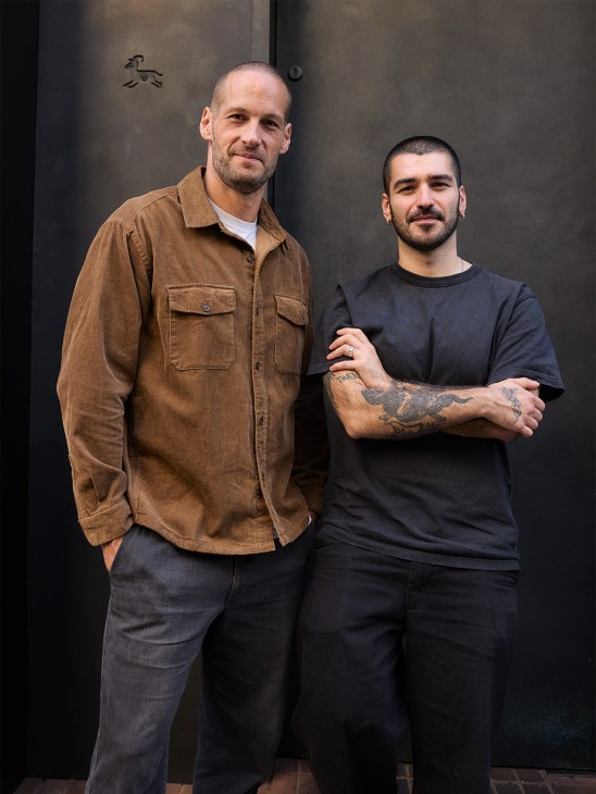 Chef Sertac Dirik and restaurateur David Carter stand together against a dark wall at Kid restaurant in Soho.