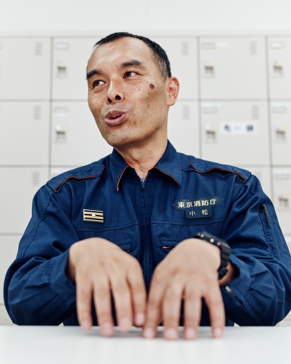 Veteran pump-truck leader Masatoshi Komatsu in Tokyo Fire Department uniform speaking about rescue operations.