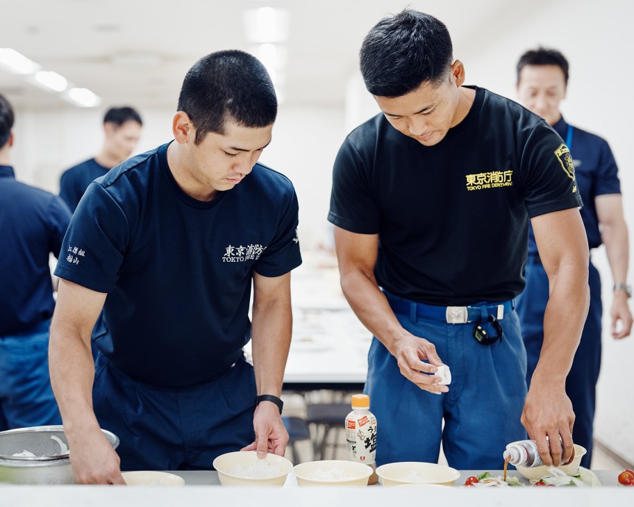 Tokyo Fire Department firefighters prepare food in a kitchen during their early dinner shift.