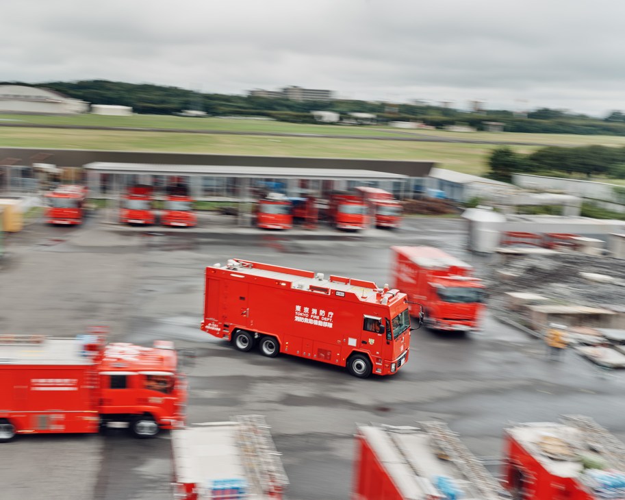 Tokyo Fire Department's Hyper Rescue 8 hazmat team in red trucks leaving the station on an emergency call