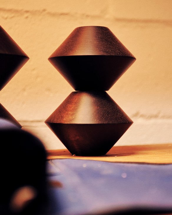 Stacked geometric sculptural forms by Michael Haynes with warm lighting and shadows.
