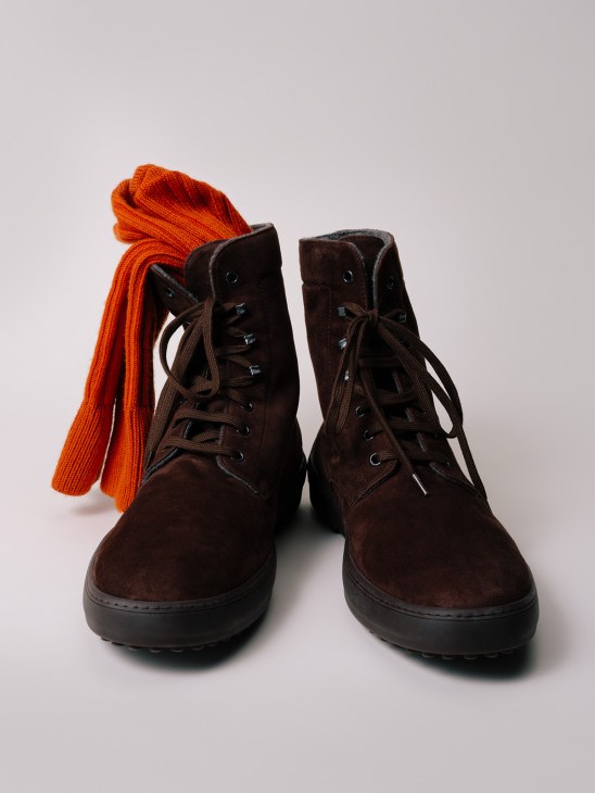 Dark brown suede lace-up boots with black sole and bright orange ribbed socks.