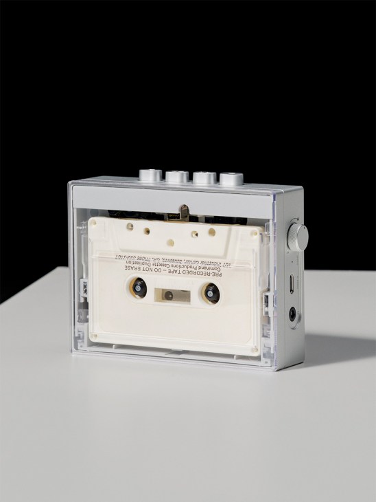 Fiio CP13 portable cassette player with silver casing and cream-colored tape visible inside.