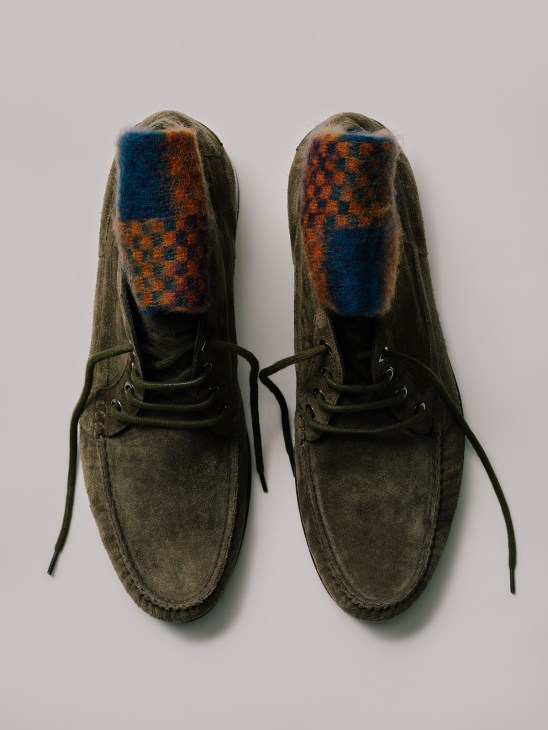 Pair of olive suede boots with blue and orange patterned socks by Manolo Blahnik, shown from above.