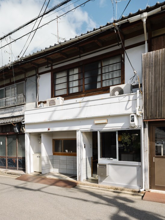 Iwashi Coffee storefront in Kyoto's Nishijin district with white facade and wooden upper floor