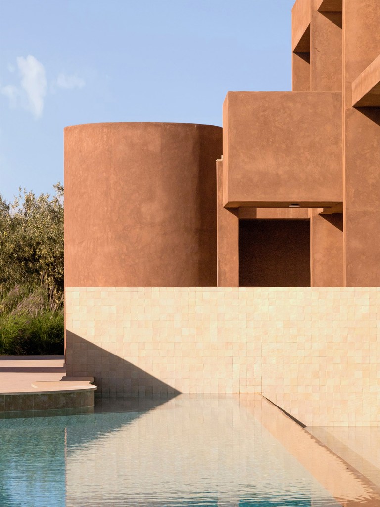 Terracotta-colored modernist building with reflecting pool at Villa El Fida in Marrakech, Morocco