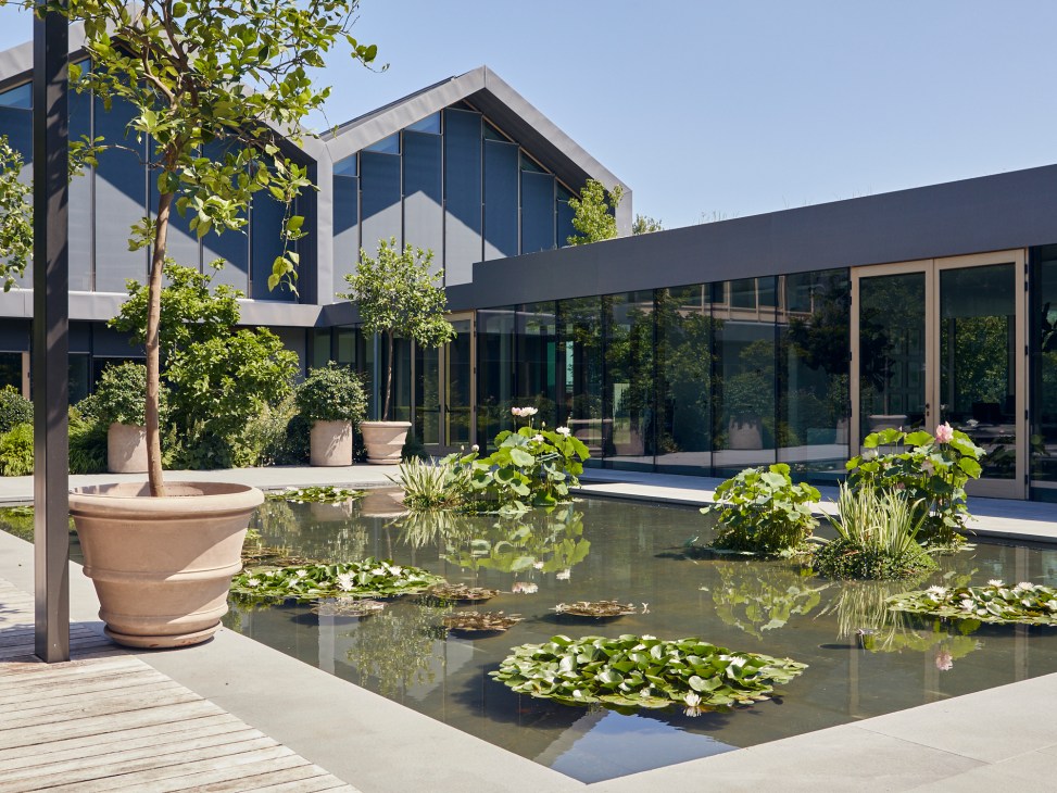 Central pond with reflective water surface at Davines Village campus