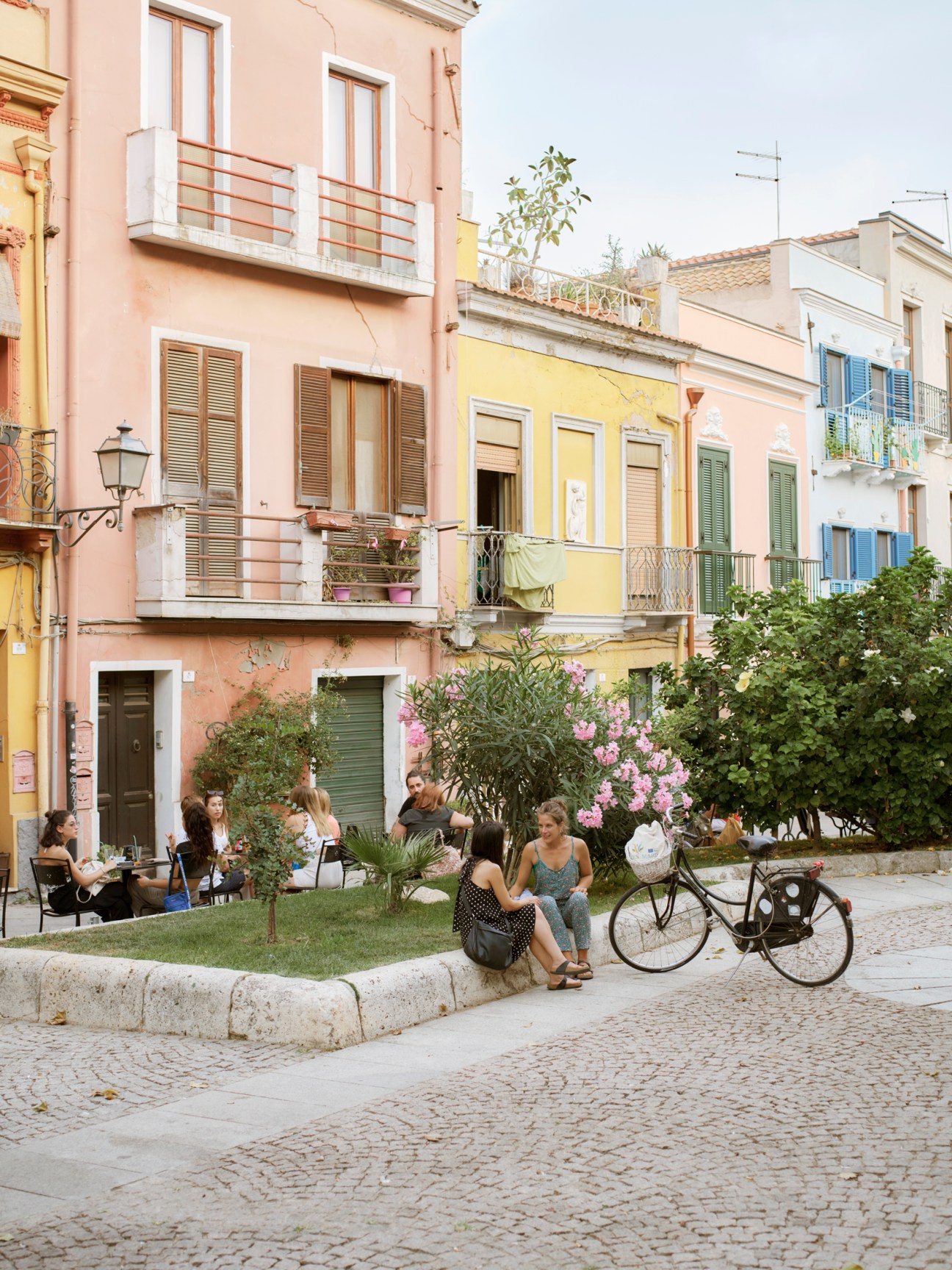 People walking through Piazza San Domenico with historic buildings and outdoor seating areas