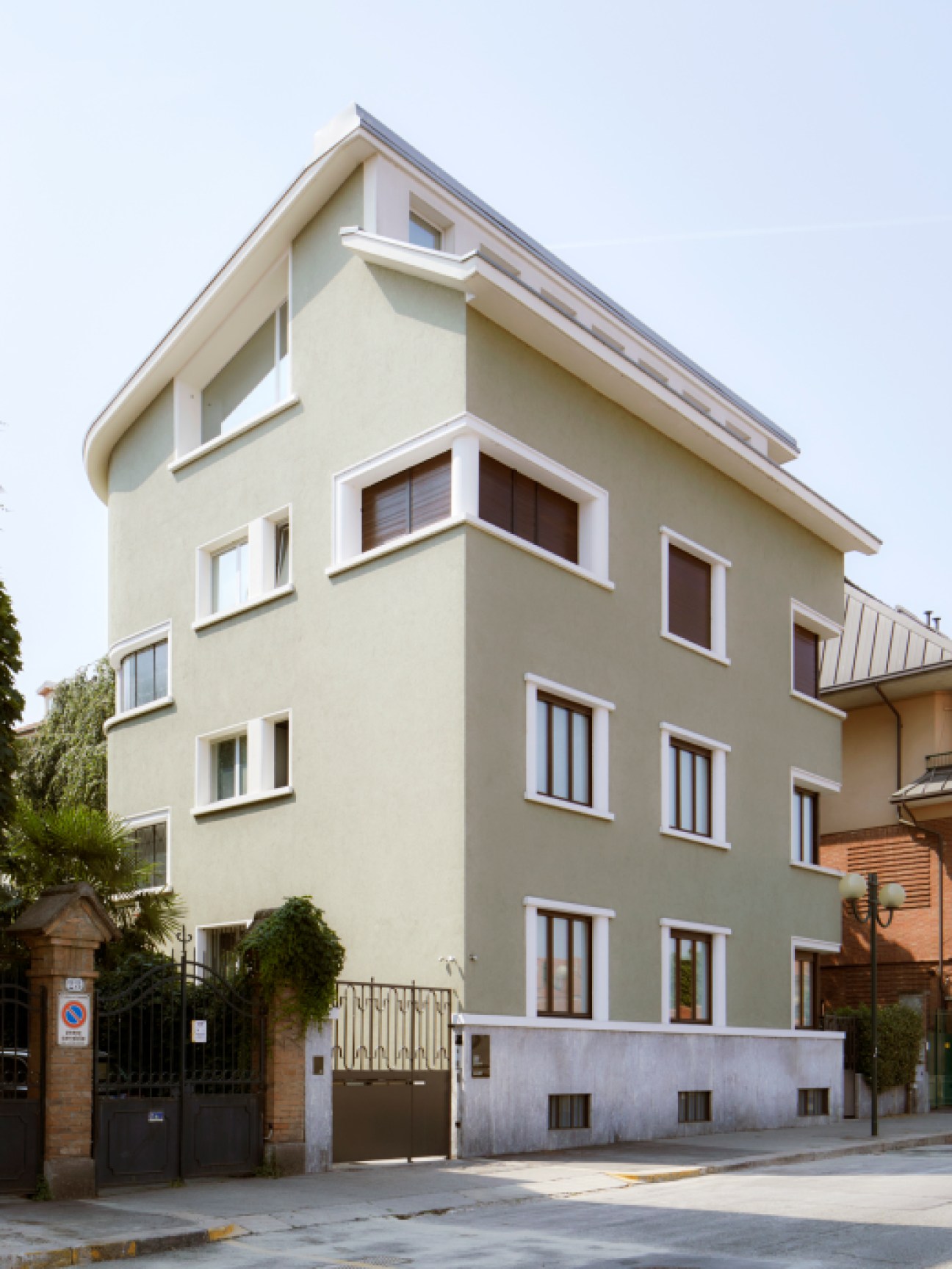 A modern beige residential building with white window trim and curved architectural details