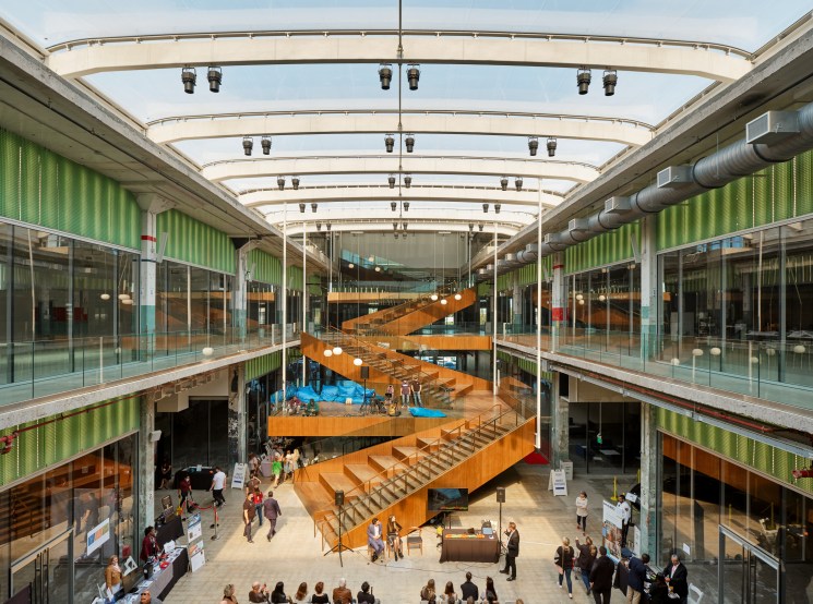 Interior atrium of Post Houston with orange zigzag staircase and people gathered below