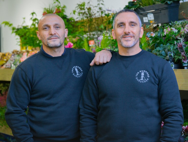 Alejandro Beltran and Peter Milne, founders of The Nunhead Gardener, stand together in their garden centre surrounded by plants.