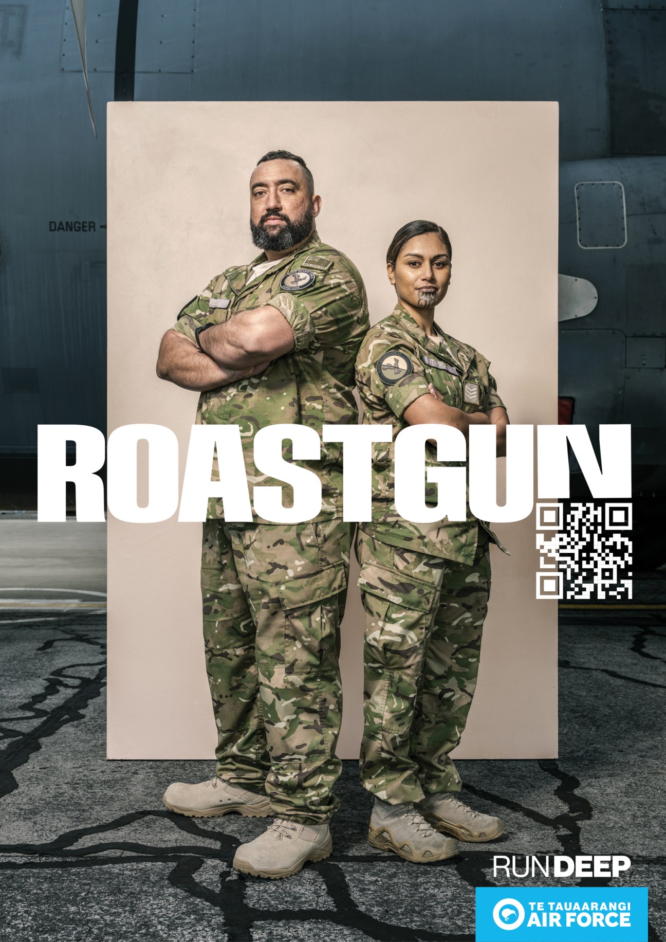 Two air force personnel in camouflage uniforms standing back-to-back with 'ROASTGUN' text and QR code overlay