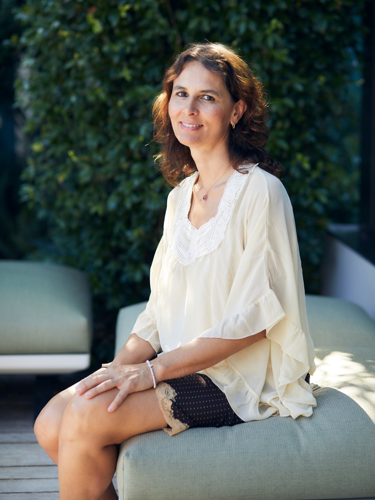 Sonia Ziveri, Davines' chief sustainability officer, sitting on outdoor furniture in a modern setting