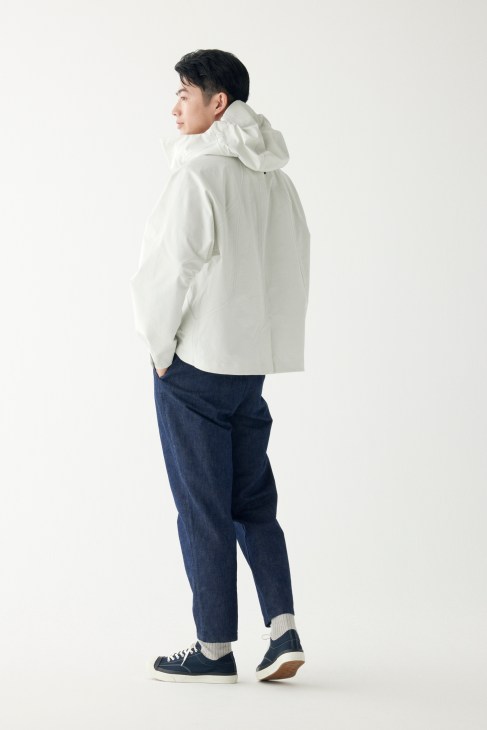 Man in technical jacket with relaxed trousers and white trainers