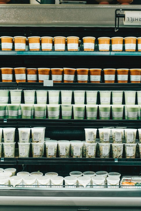 Shelves of white containers filled with prepared foods and salads at Summerhill Market