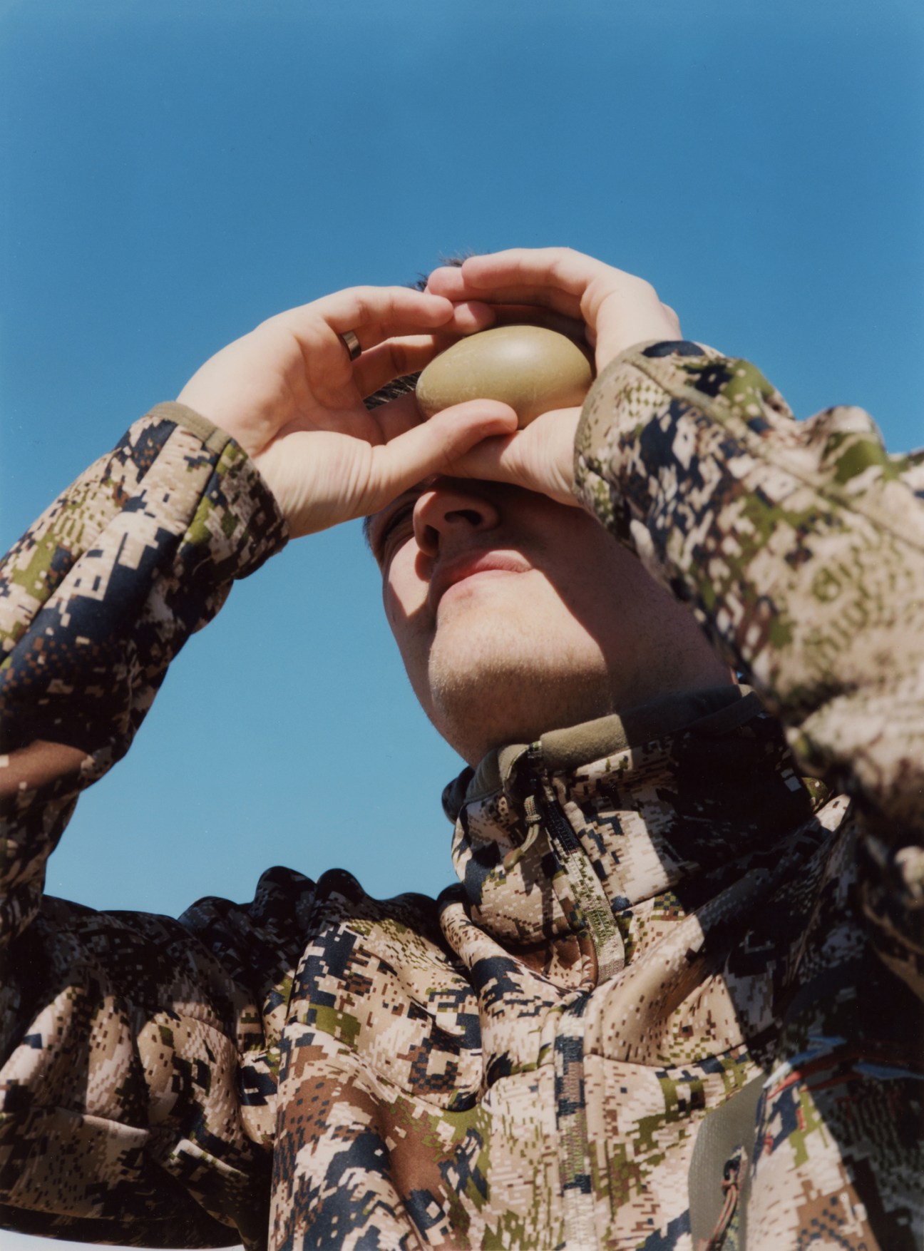 Árni Örvarsson examining an eider duck egg to gauge the phase of incubation