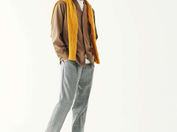 Man wearing Herno jacket, Eleventy polo shirt, and Giabs Archivio shorts with brown suede shoes and yellow scarf.