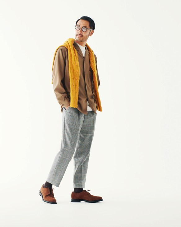 Man wearing Brooksfield jumper, District United Arrows shirt, and Cellar Door trousers with Church's shoes and Eyevan glasses.