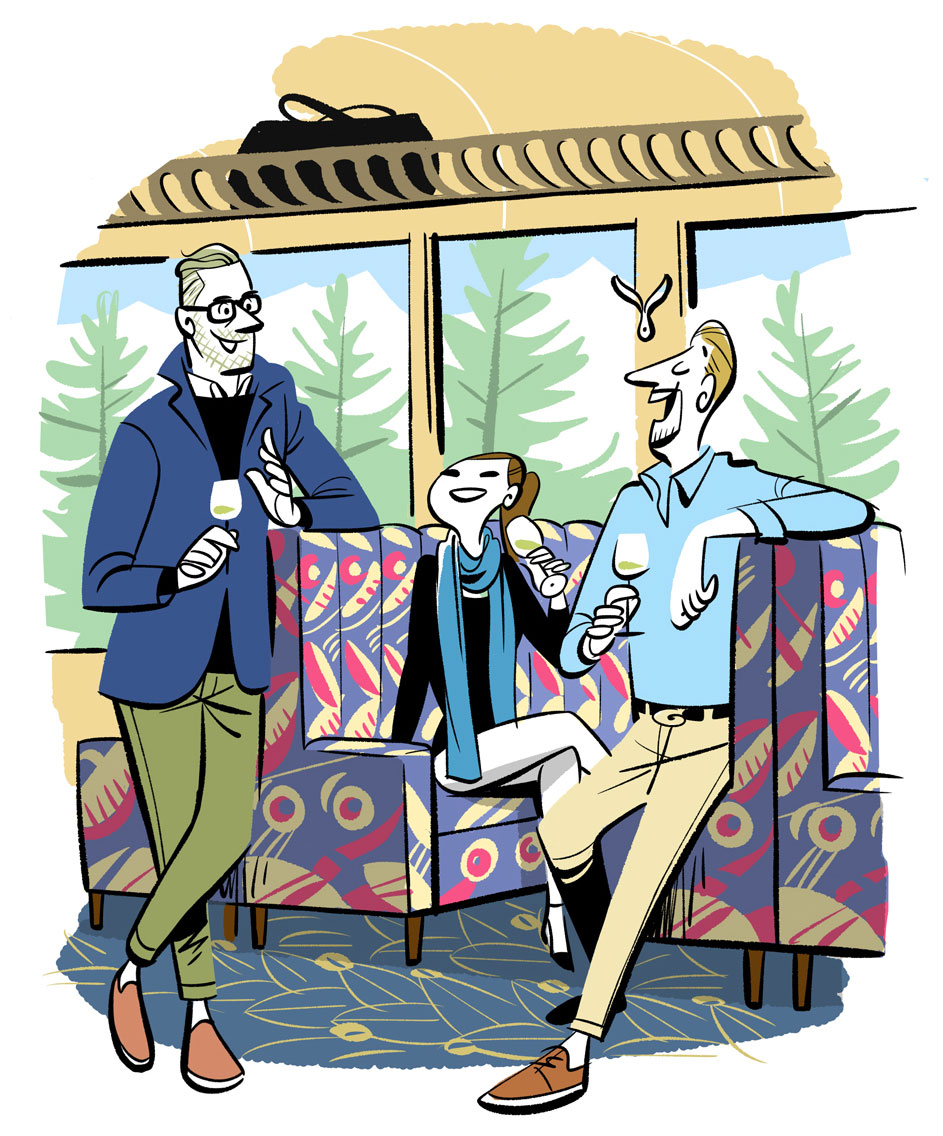 Two men in business casual attire sitting in colorful patterned train seats, holding wine glasses