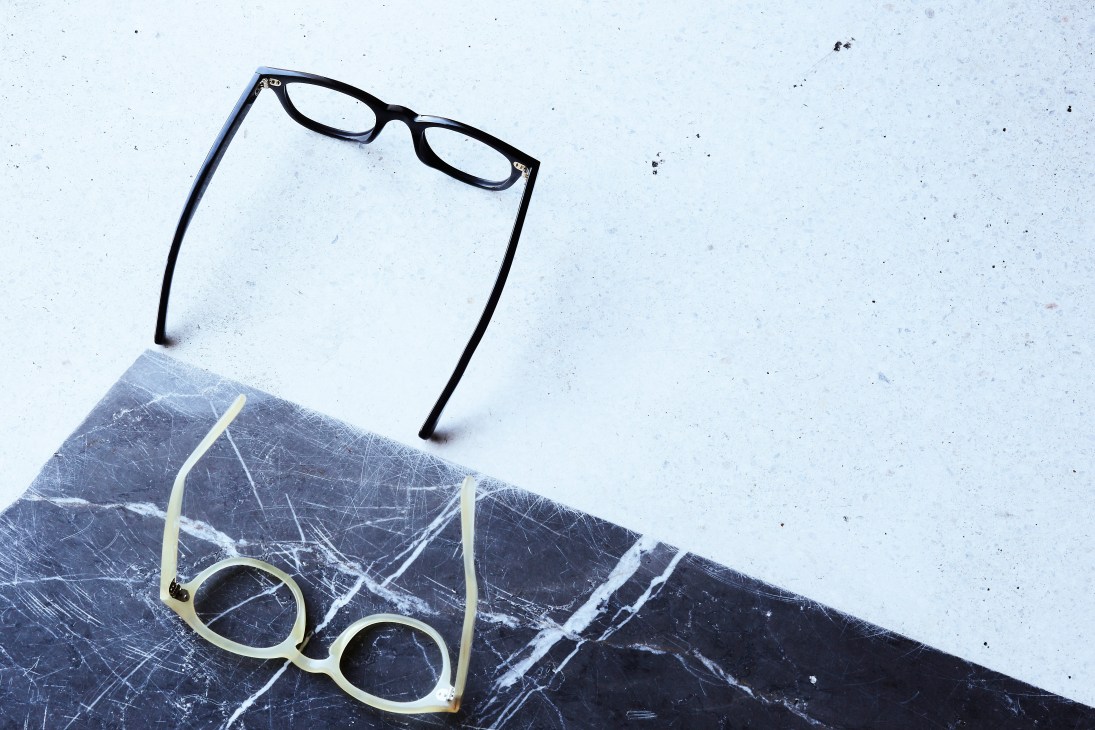 Collection of Lewis Fredericks eyeglasses in various vintage-inspired styles displayed on marble surface