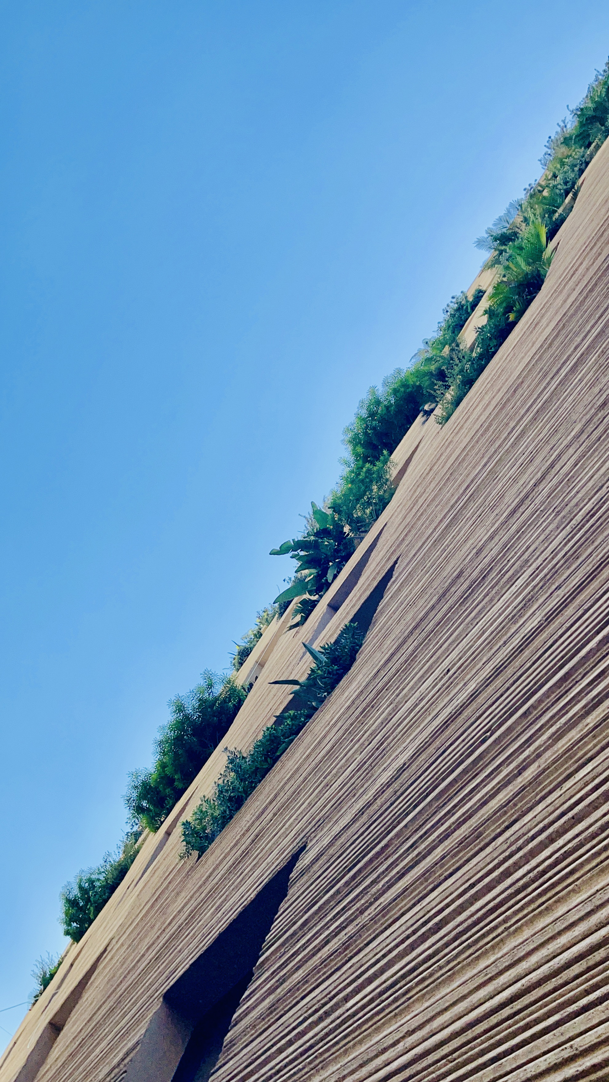 Stone Garden building in Beirut with stepped concrete balconies featuring integrated planters and vegetation