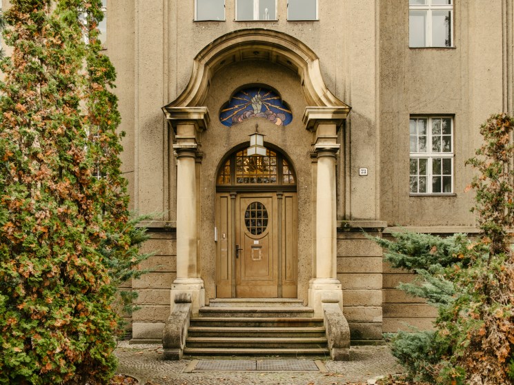 Ornate Art Nouveau building entrance with mosaic detail above the door.