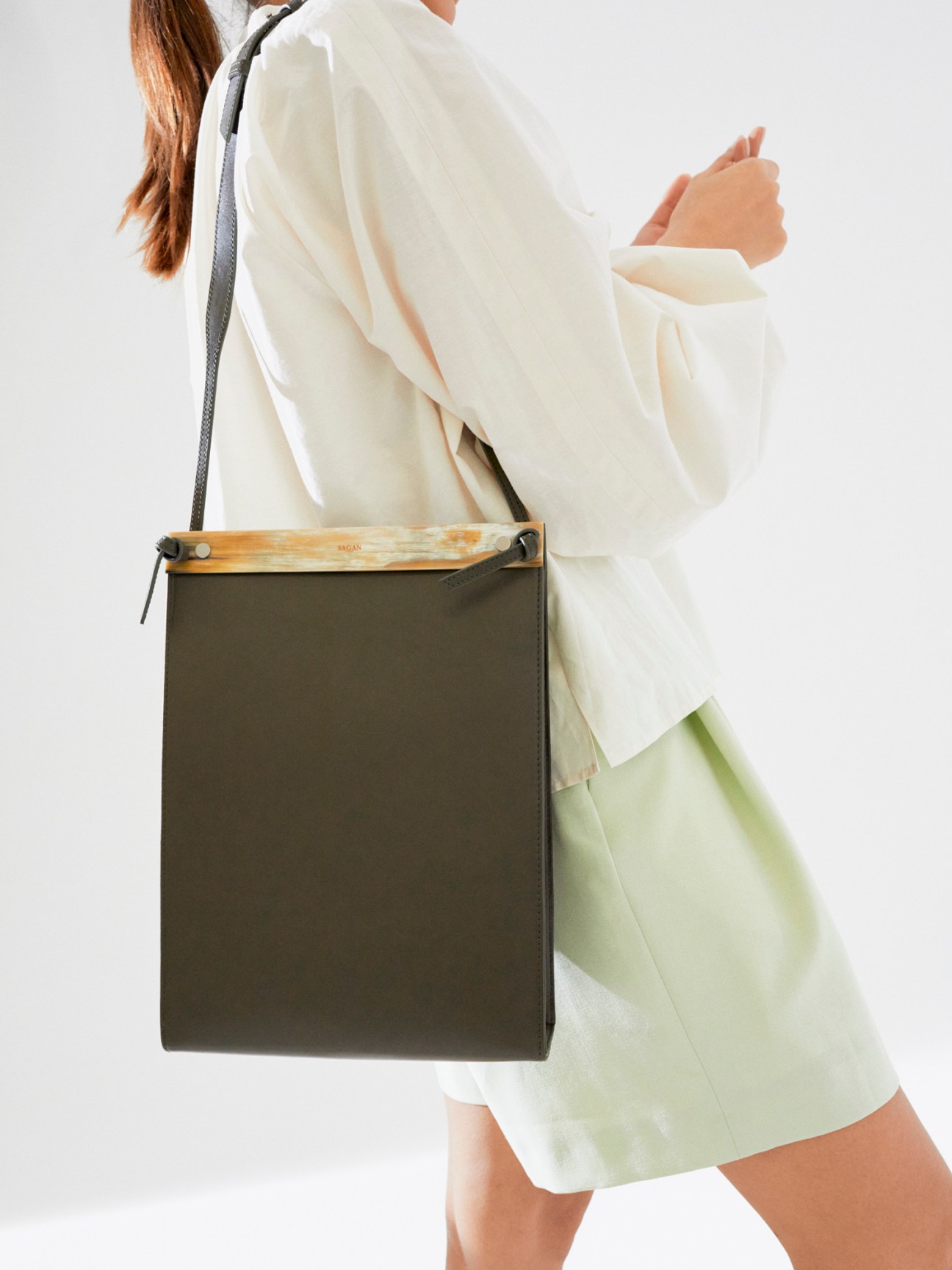 White collared shirt and light green shorts laid flat on white background