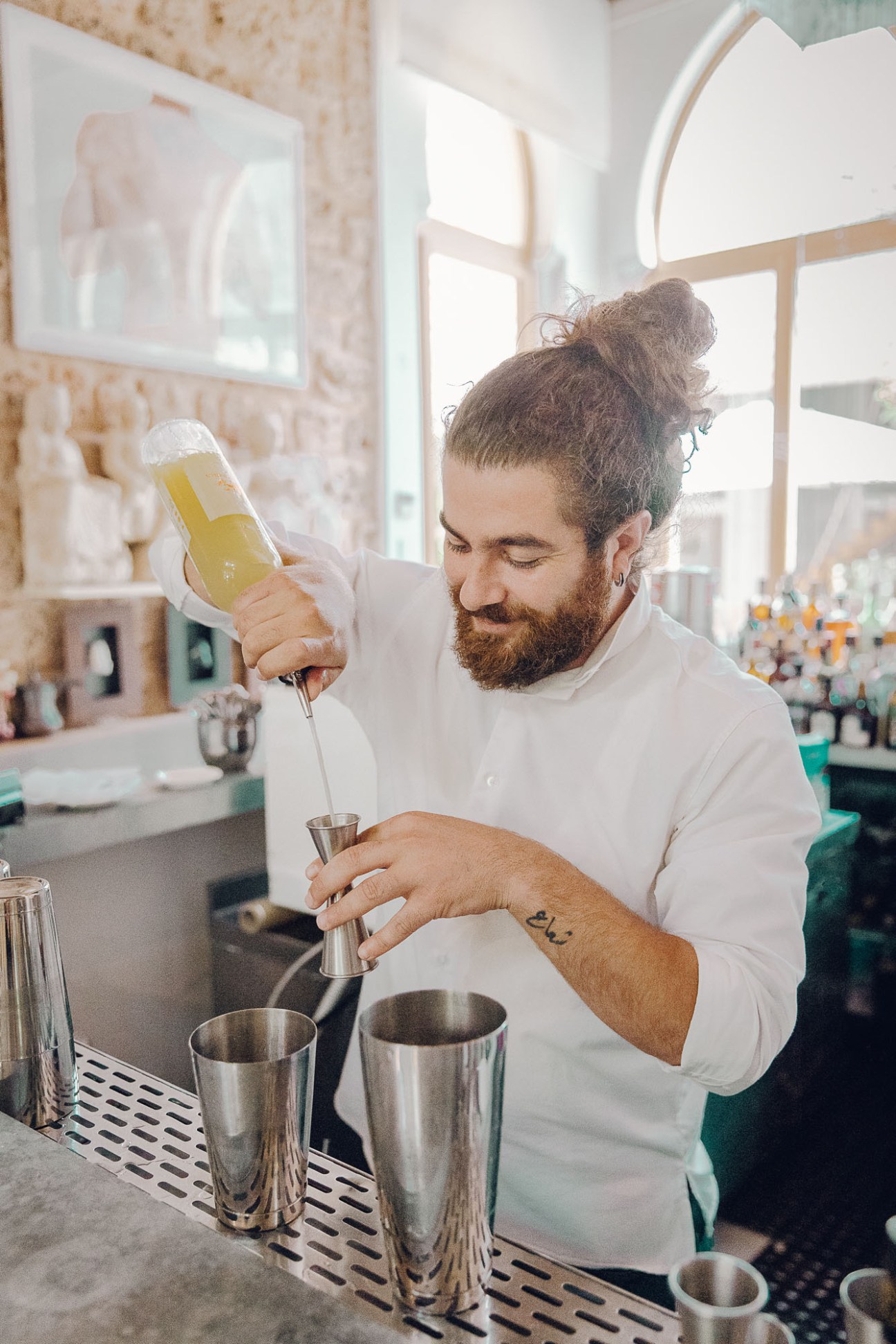 Bartender Boudy el Hussain pouring a yellow cocktail at the Arthaus bar.