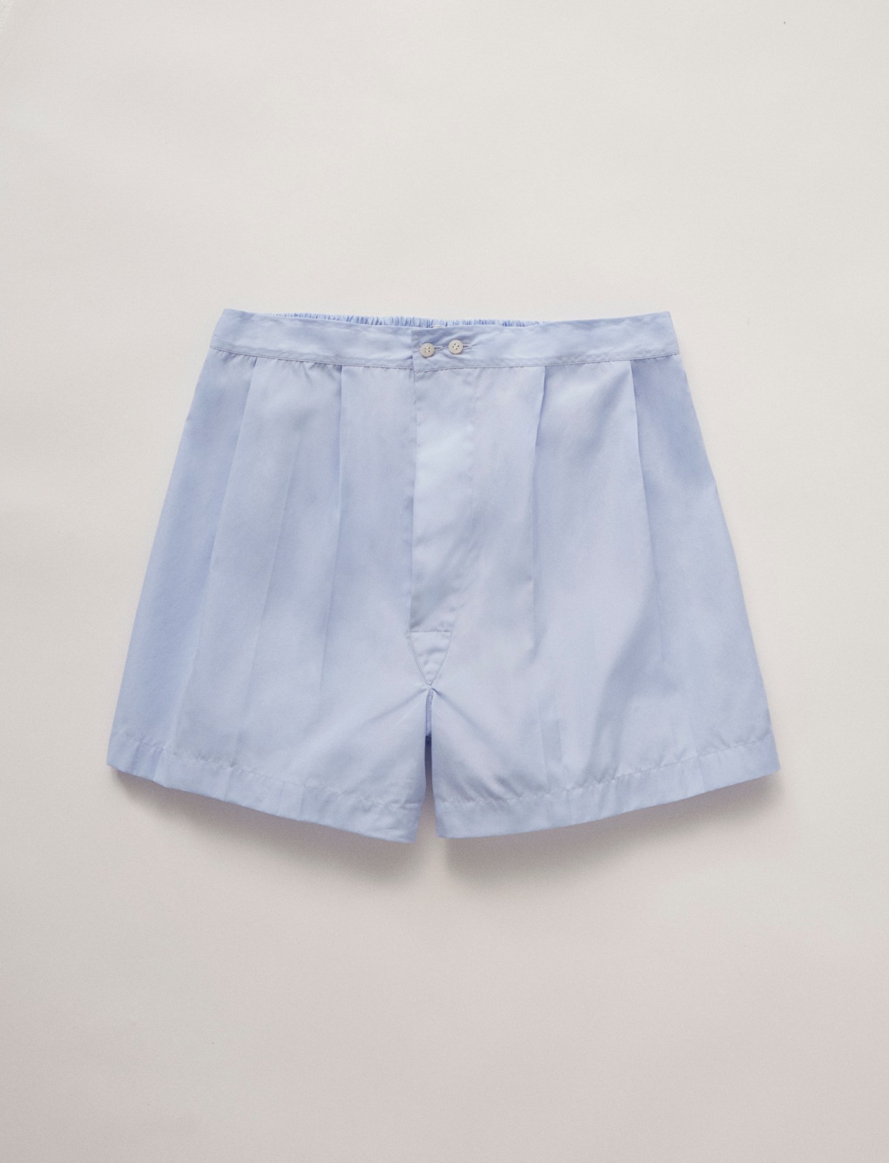 Light blue boxer shorts by Charvet with button fly closure on neutral background