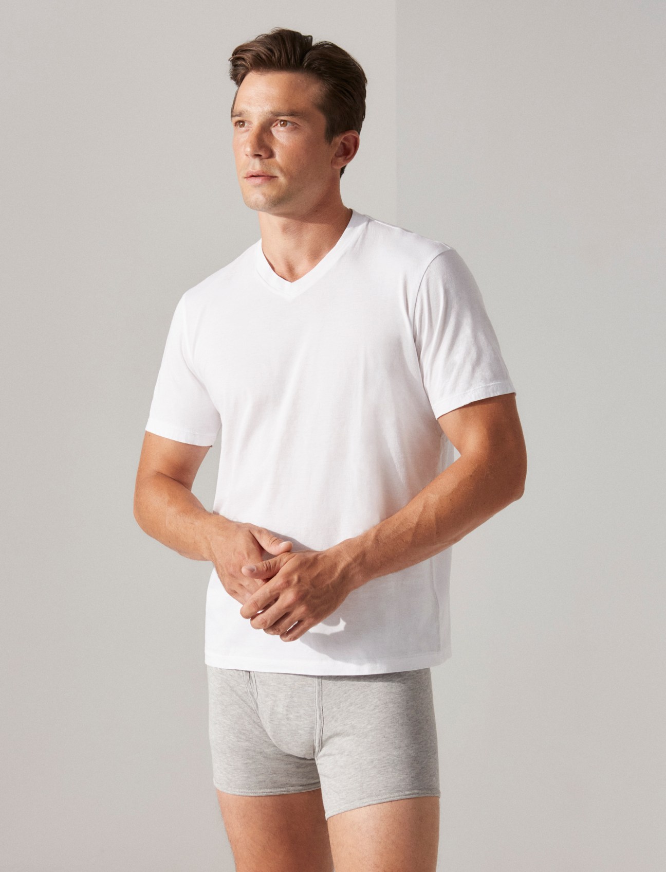 Model wearing white v-neck t-shirt and gray underwear in casual styling