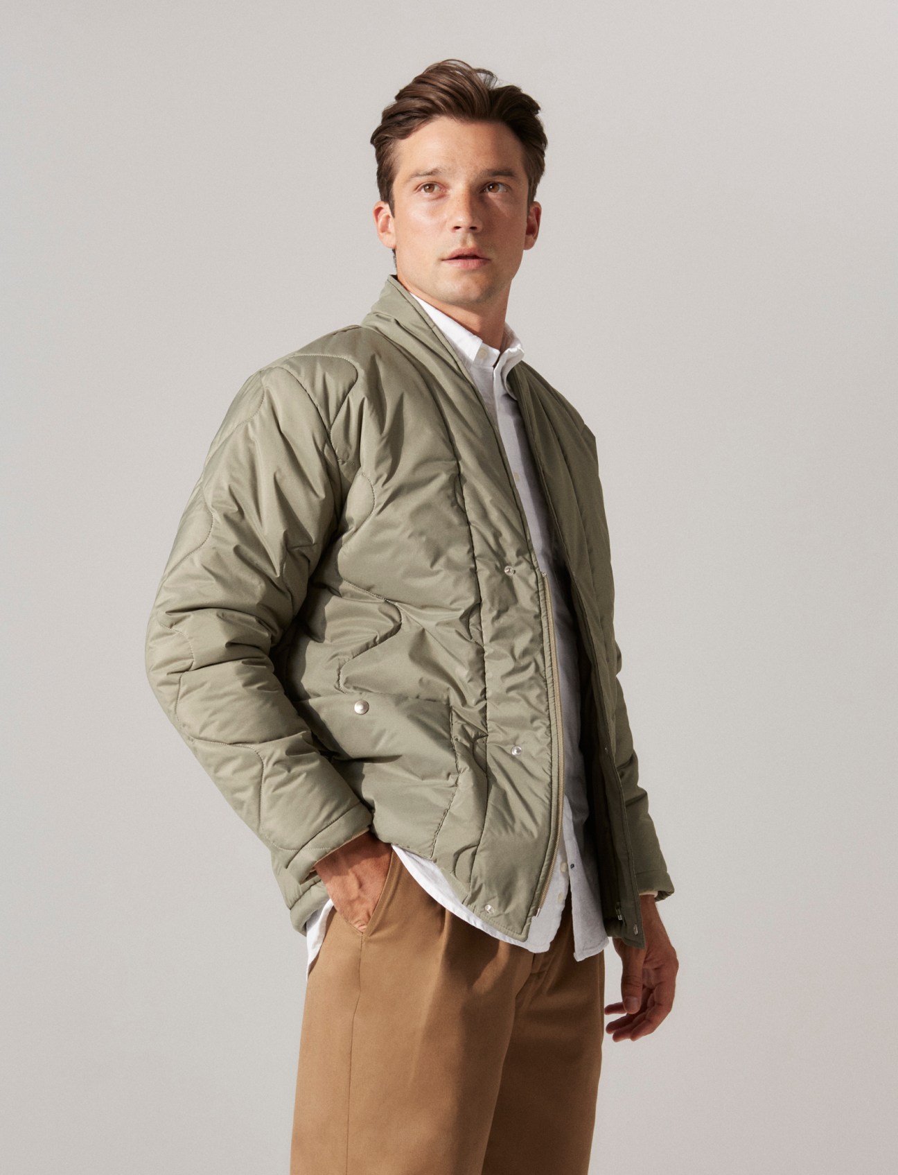 Model in light jacket, checked shirt and tailored trousers