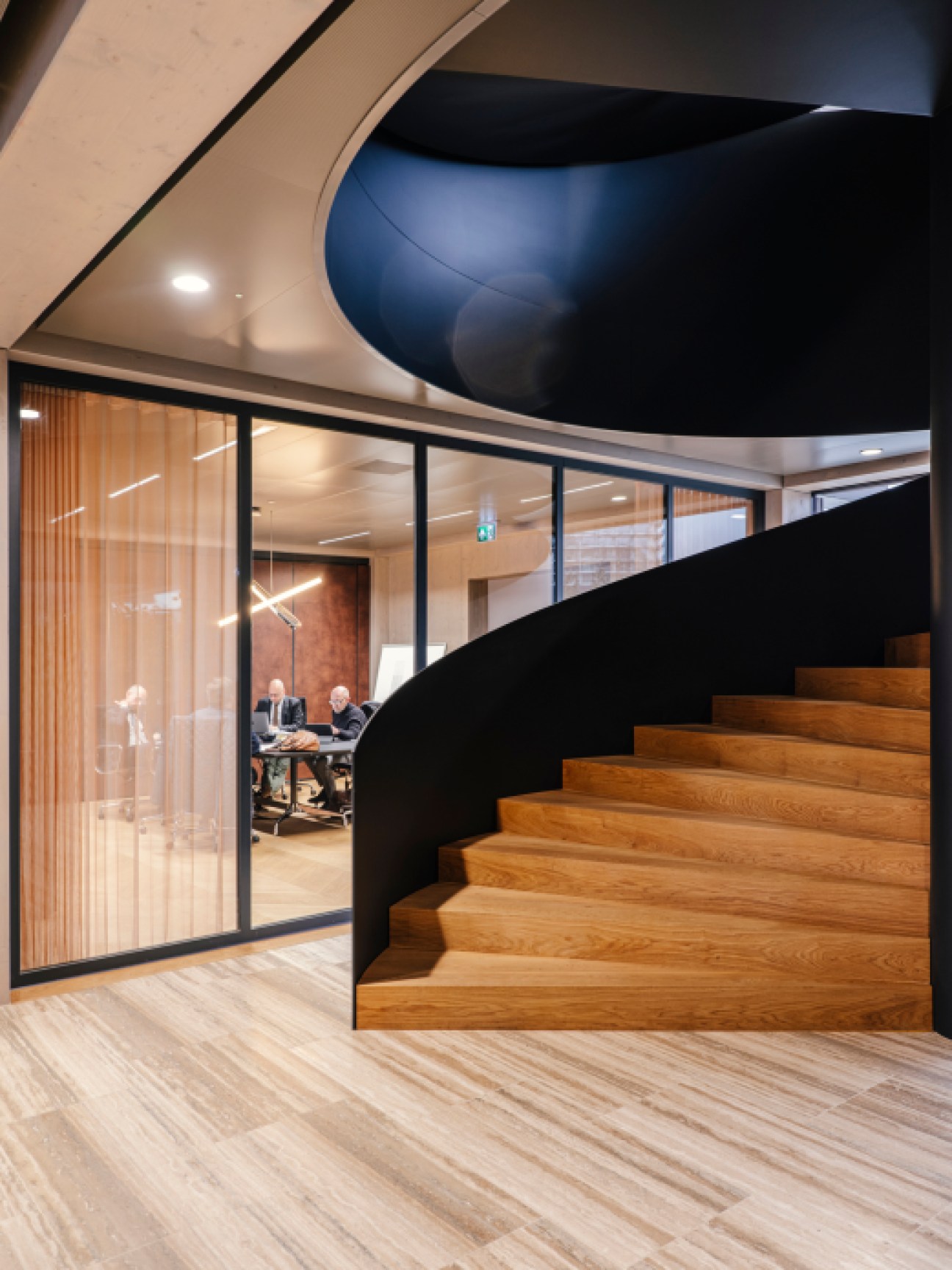 Curved wooden staircase with black steel railings inside Floating Office Rotterdam's modern timber-framed interior