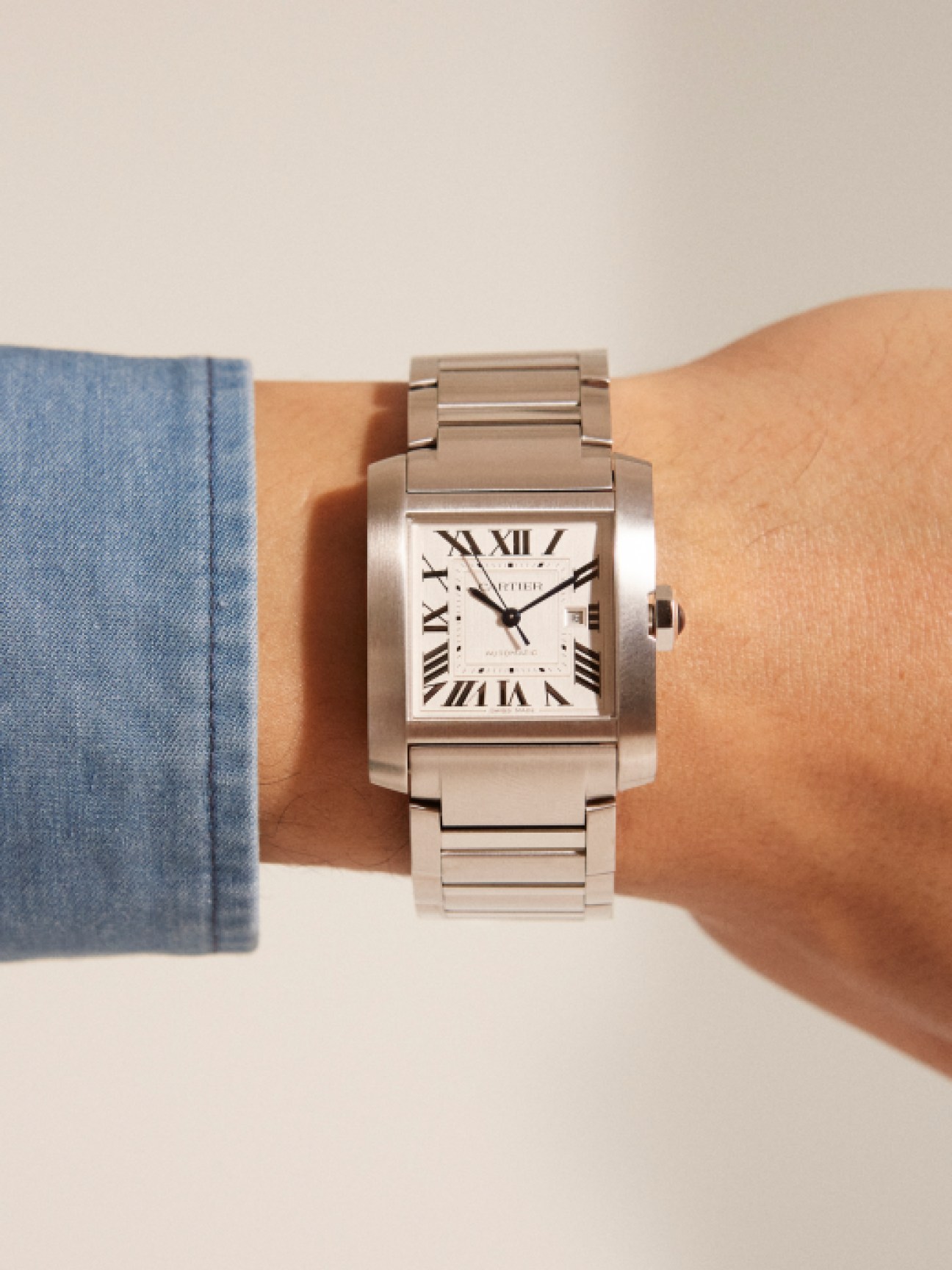 Cartier Tank Française watch with rectangular silver case, white dial, Roman numerals and steel bracelet