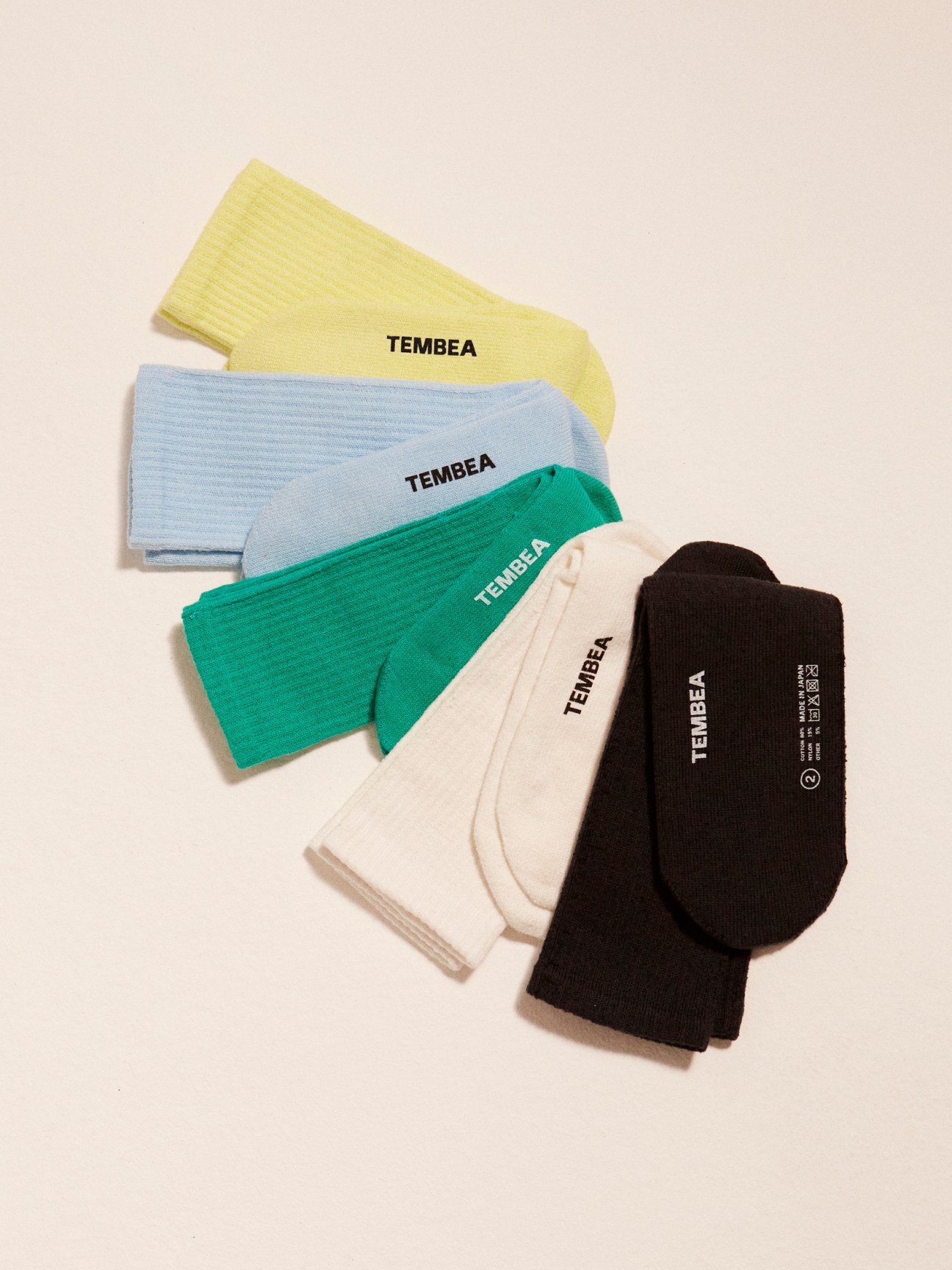 Tembea colorful socks in yellow, light blue, green, cream and black with seamless toes displayed on neutral background.