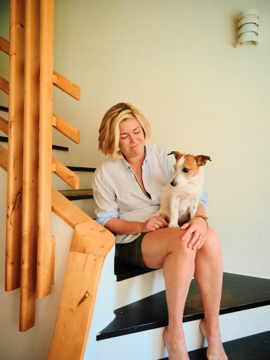 Portrait of Laura Aalto sitting in her restored Aalto apartment with period furniture and clean modernist interior