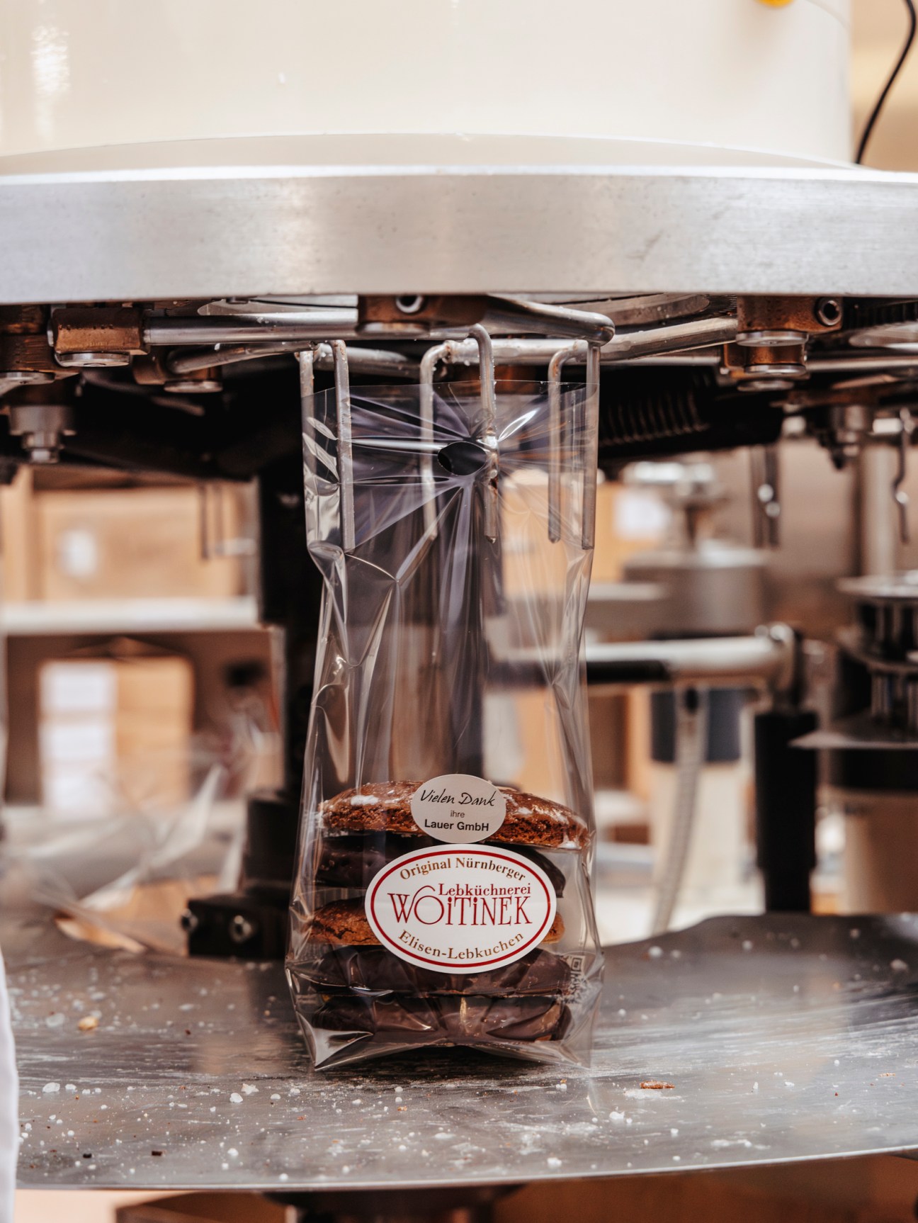 Clear plastic bag of Woitinek Lebkuchen gingerbread cookies being filled by industrial packaging machinery