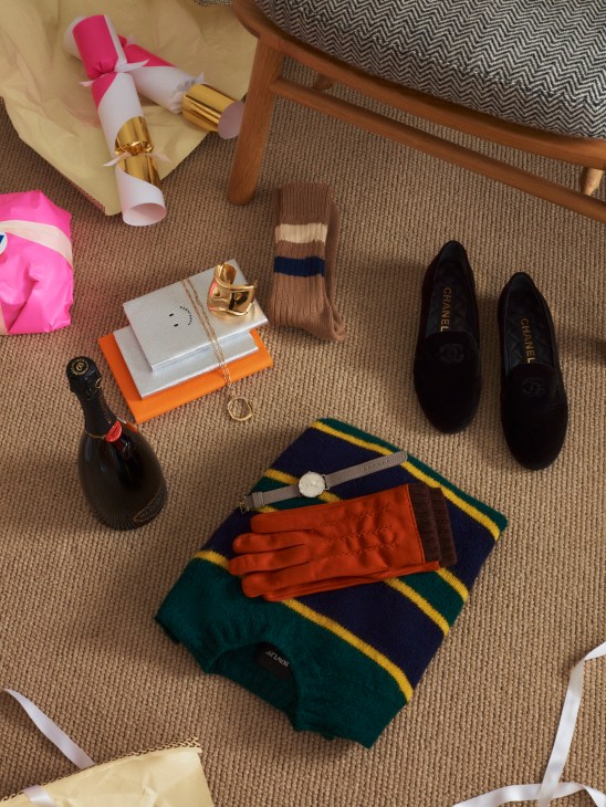 Luxury accessories including jumper, shoes, jewelry, watch and stationery arranged for gifting display